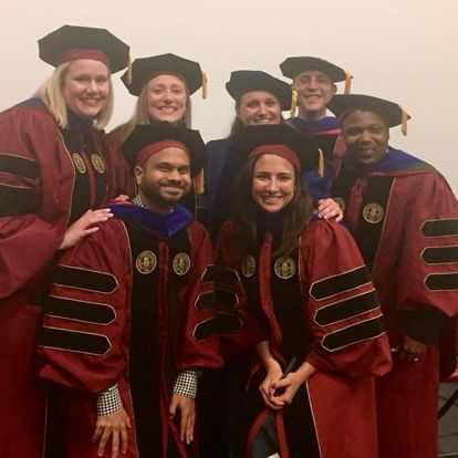 Seven individuals in their cap and gowns.