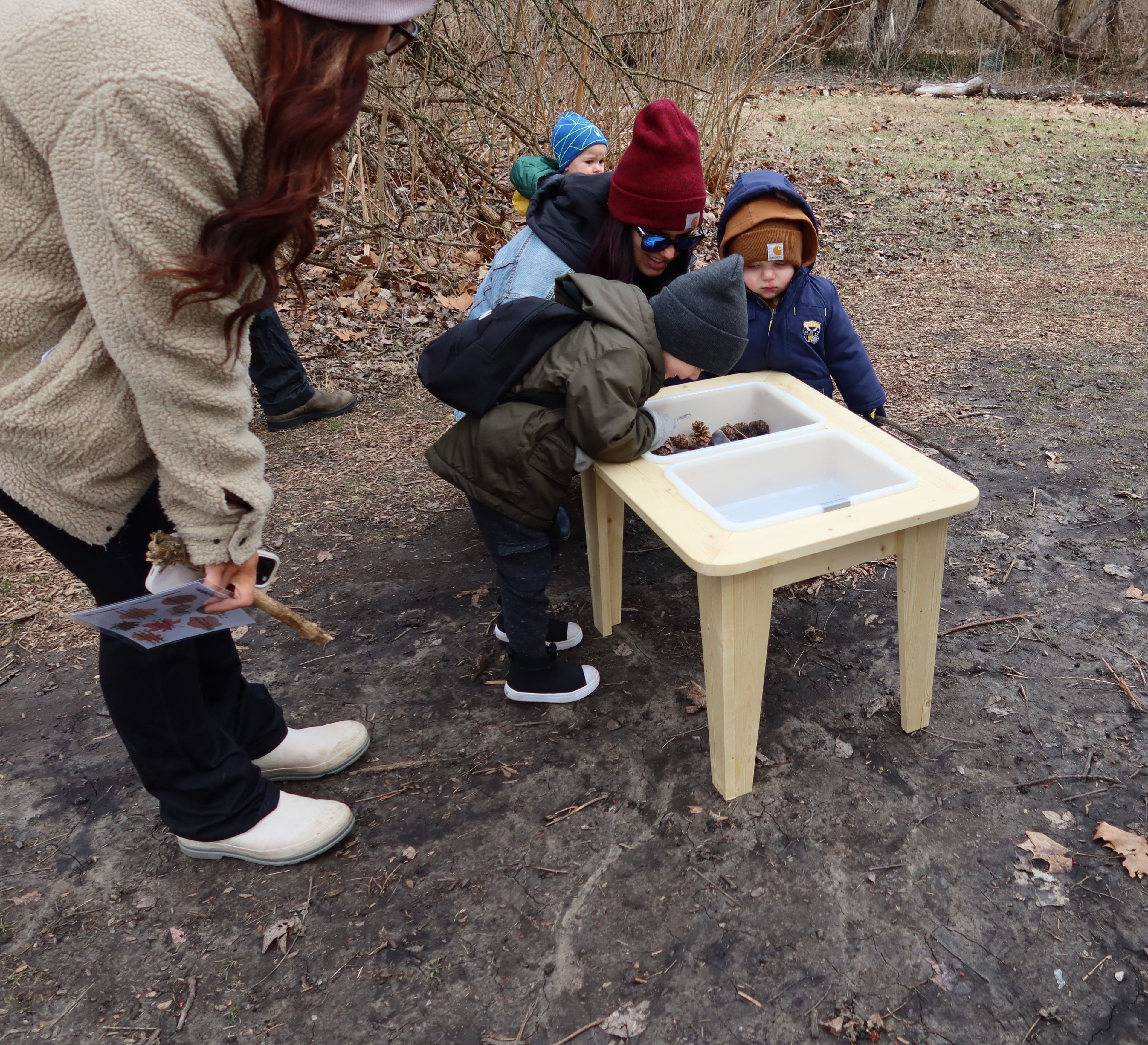 Children investigating an sink and its contents outside.