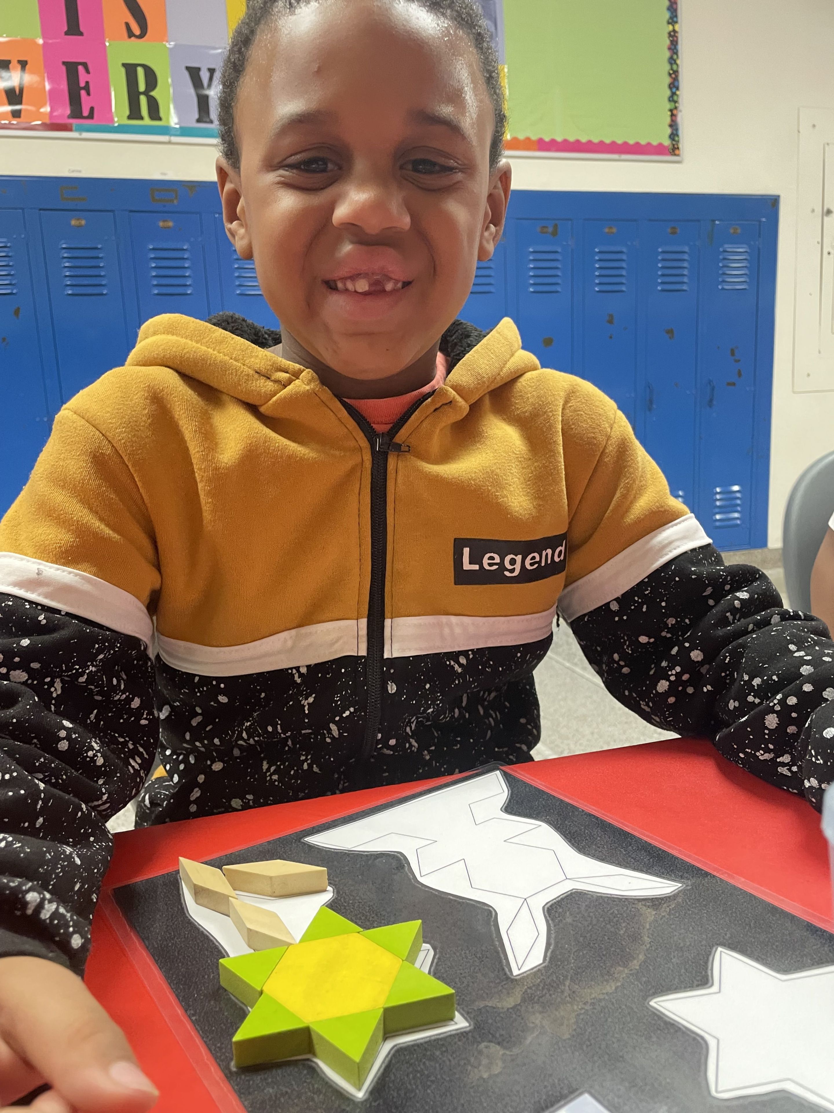 Paper cutouts in front of a smiling student.