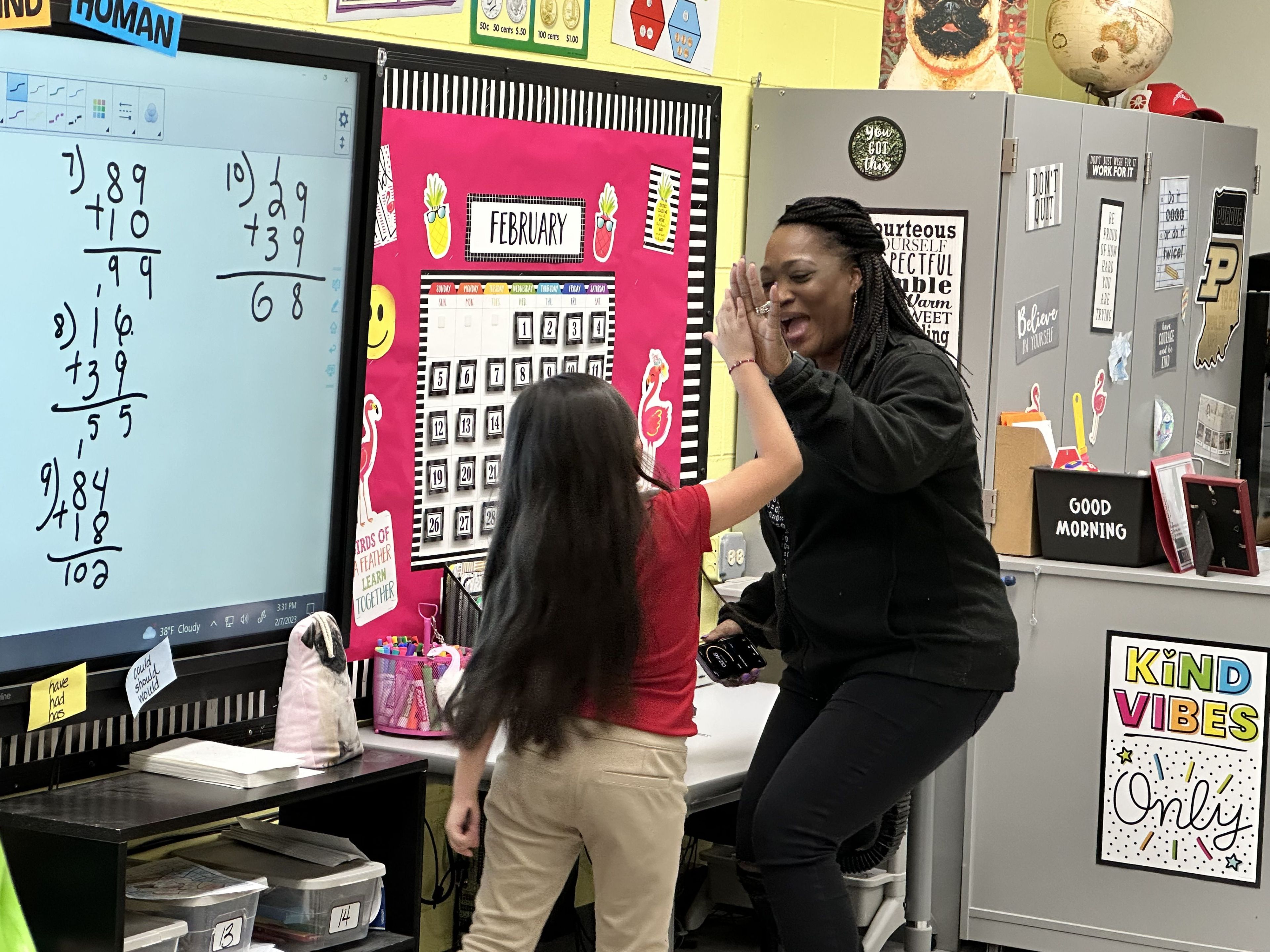 Darlene and a student giving a high five.