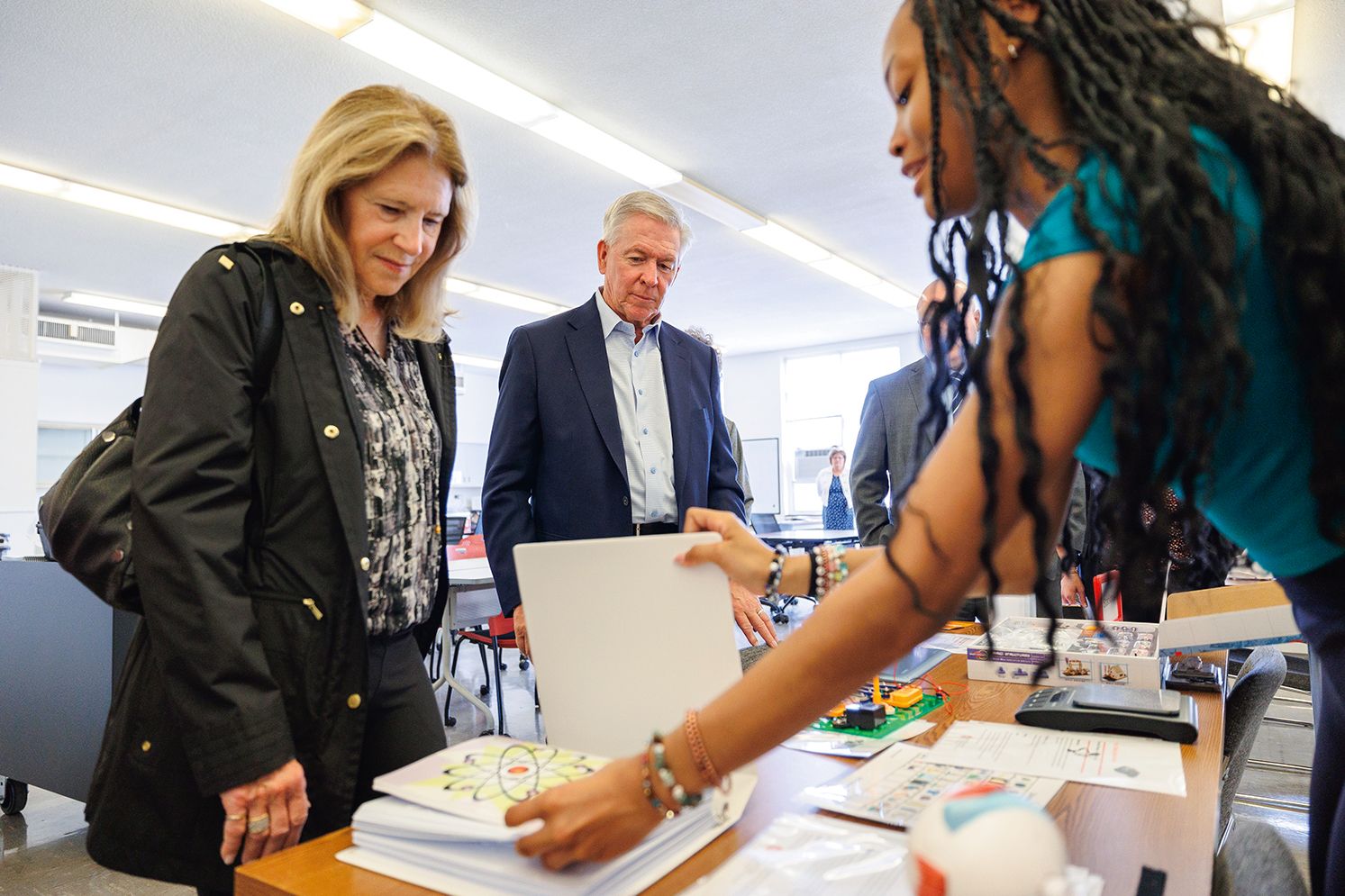 Sharon and Steve Hagge watch a student demonstrate one of the assistive technological tools used in the classroom.